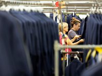 Workers are surrounde by complete suits as they inspect them before they are shipped out at the Joseph Abboud manufacturing plant in New Bedford, MA.   [ PETER PEREIRA/THE STANDARD-TIMES/SCMG ]